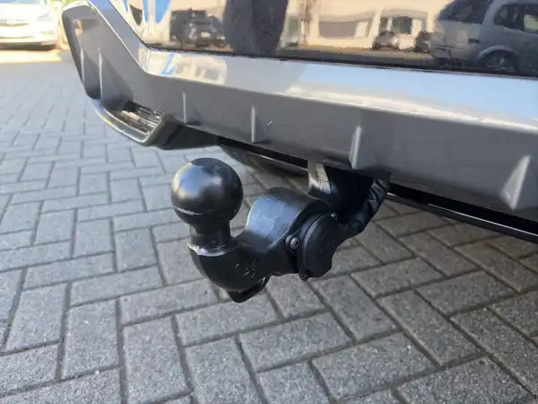 Das Bild zeigt die hintere Ansicht eines Fahrzeugs mit einem abnehmbaren Anhängerkupplung. Das Fahrzeug ist in Schwarz und es handelt sich um eine Nahaufnahme von der Hinterseite.