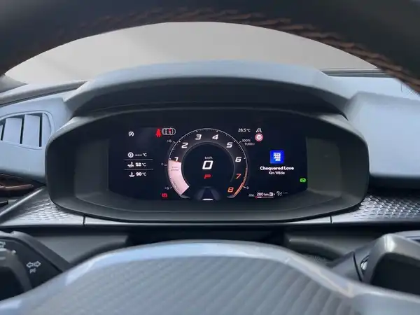 Das Bild zeigt das Innenleben eines Fahrzeugs, das Armaturenbrett mit einem digitalen Display, das aktuelle Fahrzeugdaten anzeigt.