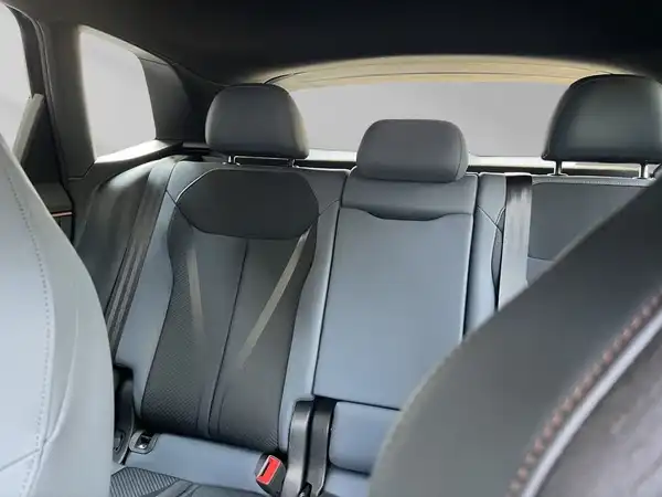 Das Bild zeigt den Innenraum eines Fahrzeugs, spezifisch die Rücksitze. Die Sitze sind schwarz.