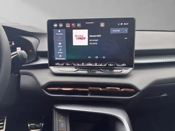 Das Bild zeigt das Innere eines CUPRA TERRAMAR mit einem Bildschirm, der Informationen und eine Anzeige zeigt. Die Interieurfarbe ist schwarz.