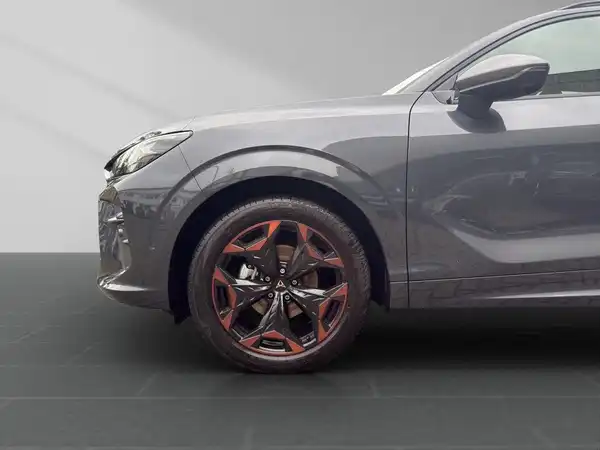 Seitenansicht eines grauen Fahrzeugs mit sportlichen Felgen.