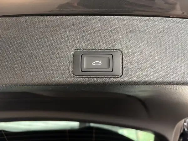 Das Bild zeigt einen Innenraum des Fahrzeugs, insbesondere einen Schalter mit schwarzem Gehäuse auf einer strukturierten Oberfläche.