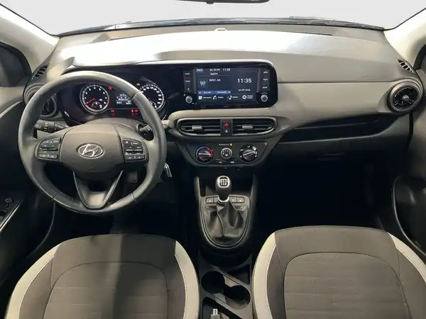 Das Bild zeigt das Innere eines Hyundai i10, aufgenommen aus der Vogelperspektive mit einem schwarzen Interieur und grauen Akzenten.