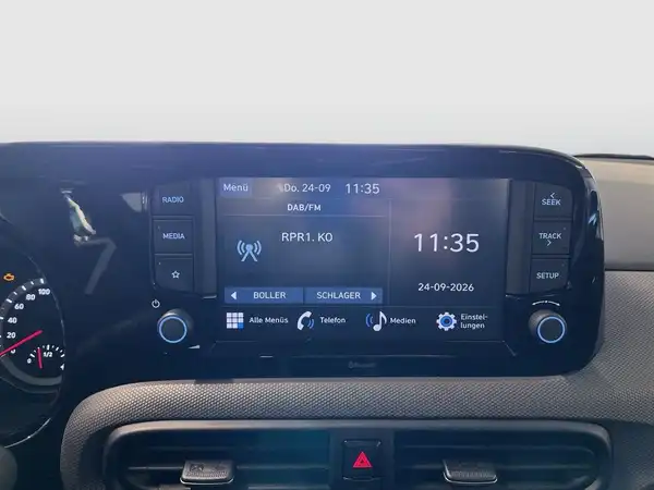 Innenaufnahme des Fahrzeugs Hyundai I10, mit schwarzem Interieur und Bildschirmanzeige.