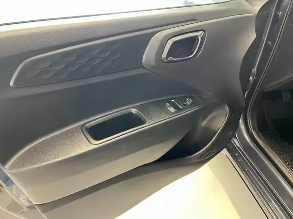 Das Bild zeigt die Innenseite der Fahrertür eines Fahrzeugs, die hauptsächlich in Schwarz gehalten ist.