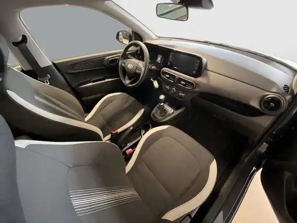 Aufnahme des Fahrzeuginnenraums eines Hyundai I10. Die Sitze sind schwarz mit grauen Akzenten.