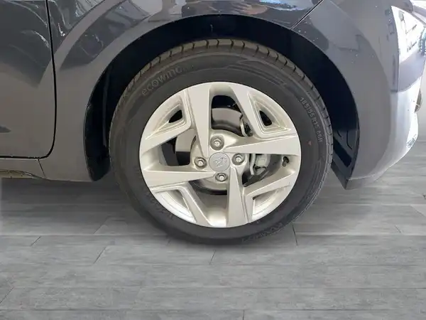 Das Bild zeigt einen grauen Hyundai i10 von der Seite, mit Fokus auf dem Rad und der Felge.