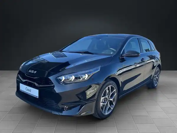 Ein Bild eines KIA Ceed, das von vorne aufgenommen wurde. Das Fahrzeug ist in schwarz und hat einen markanten Schriftzug 'Ceed' auf der Anzeige.