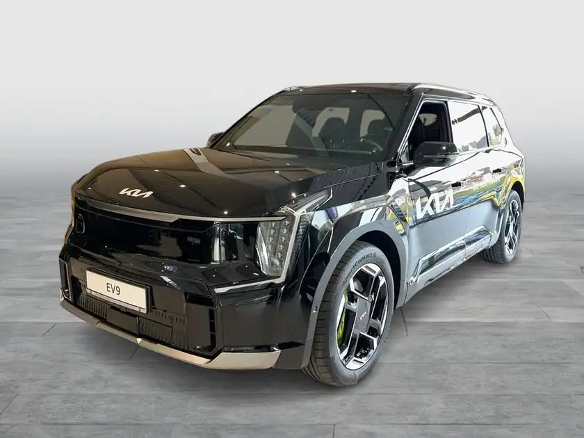 Das Bild zeigt einen KIA EV9 aus der Vorderansicht in schwarz. Es gibt markante Texteinblendungen auf dem Foto.