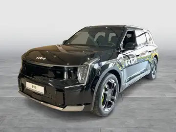 Das Bild zeigt einen KIA EV9 aus der Vorderansicht in schwarz. Es gibt markante Texteinblendungen auf dem Foto.