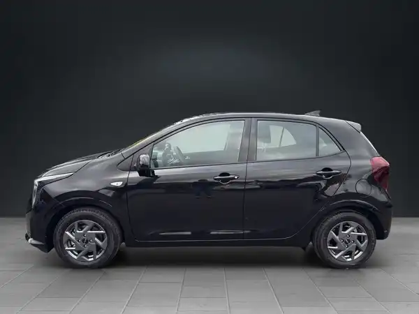 Das Bild zeigt einen schwarzen KIA Picanto aus der Seitenansicht.