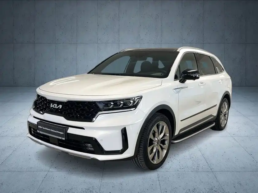 Das Bild zeigt einen weißen KIA Sorento aus der Frontansicht, mit einem Händlerlogo und anderem markanten Text.
