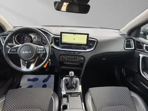 Das Bild zeigt das Innere eines KIA XCEED mit einem schwarzen Interieur, dekorativen Einsätzen und einem zentralen Display.