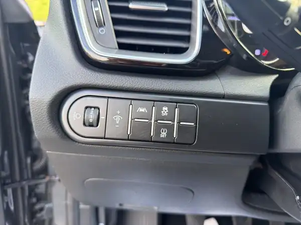 Das Bild zeigt das Innere eines Fahrzeugs, genauer gesagt eine Nahaufnahme der Bedienelemente am Armaturenbrett. Die Interieurfarbe ist schwarz.