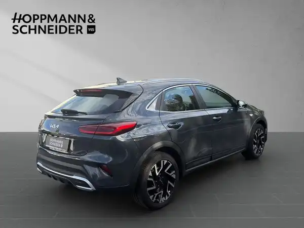 Das Bild zeigt einen KIA XCEED von hinten in grauer Farbe. Das Händlerlogo 'HOPPMANN & SCHNEIDER' ist im Bild eingeblendet.