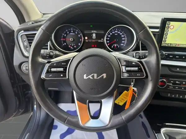 Das Bild zeigt das Innere eines KIA XCEED, mit dem Lenkrad und Armaturenbrett im Fokus. Die Innenausstattung ist schwarz.