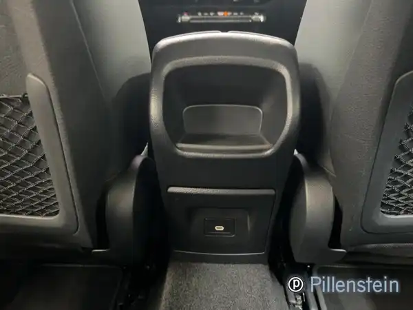 Die Innenaufnahme zeigt den hinteren Bereich des Fahrzeugs mit schwarzem Interieur. Das Bild enthält ein Händlermarkenlogo.