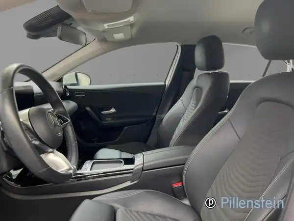 Das Bild zeigt den Innenraum eines Mercedes-Benz A 180 d. Die Sitze sind schwarz und das Bild enthält das Händlerlogo.