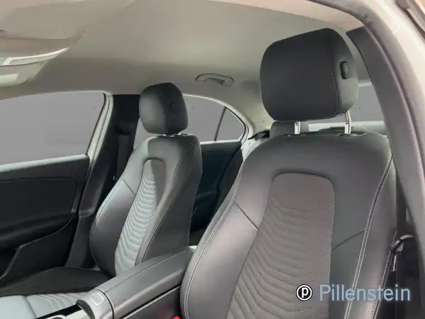 Das Bild zeigt den Innenraum eines Mercedes-Benz A 180 d mit schwarzen Sitzen und einem modernen Design.