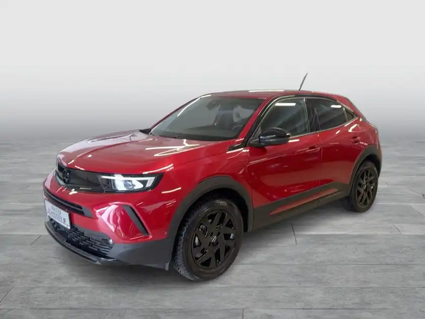 Das Bild zeigt ein rotes Fahrzeug (OPEL MOKKA) aus der Seitenansicht. Im unteren Bereich des Bildes ist das Händlerlogo 'WALTER SCHNEIDER' sowie weitere Logoelemente sichtbar.
