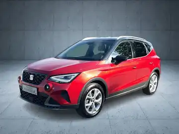 Das Bild zeigt einen rot lackierten SEAT Arona aus seitlicher Perspektive.