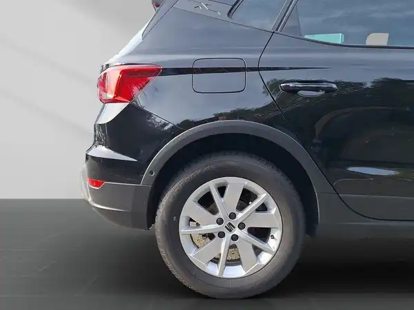Das Bild zeigt einen schwarzen SEAT Arona von der Seite.