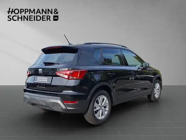 Das Bild zeigt ein schwarzes Fahrzeug, einen SEAT Arona, aus der Seitenansicht. Es enthält das Händlerlogo von Hoppmann & Schneider sowie markante Texteinblendungen.