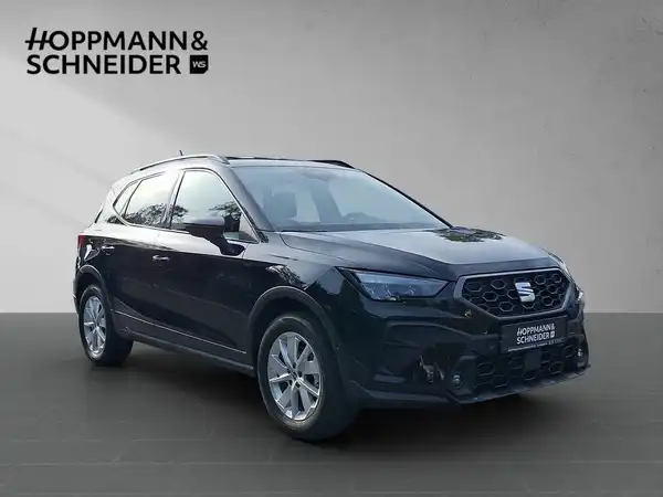 Das Bild zeigt einen schwarzen SEAT Arona von der Seite. Ein Händlerlogo ist sichtbar.
