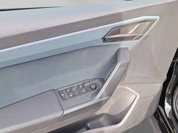 Das Bild zeigt die Innenaufnahme der Fahrertür eines SEAT ARONA, mit einer grauen und blauen Innenverkleidung und Bedienelementen.