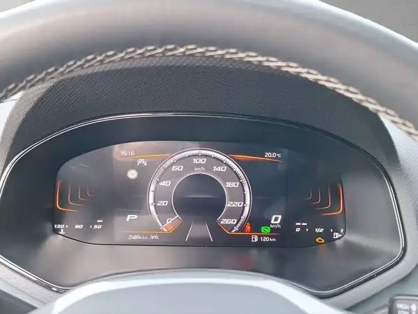 Das Bild zeigt das Cockpit eines SEAT Arona mit einem digitalen Display. Die Anzeige zeigt verschiedene Fahrzeugdaten in orange und schwarz.