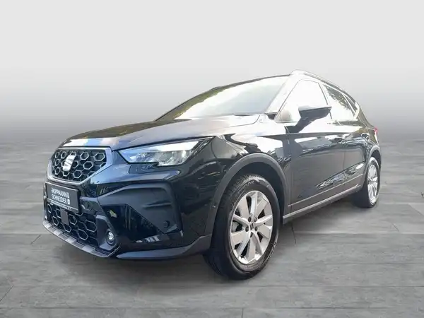 Das Bild zeigt ein schwarzes Fahrzeug (SEAT Arona) aus der Seitenansicht. Es enthält das Händlerlogo und markante Texteinblendungen.