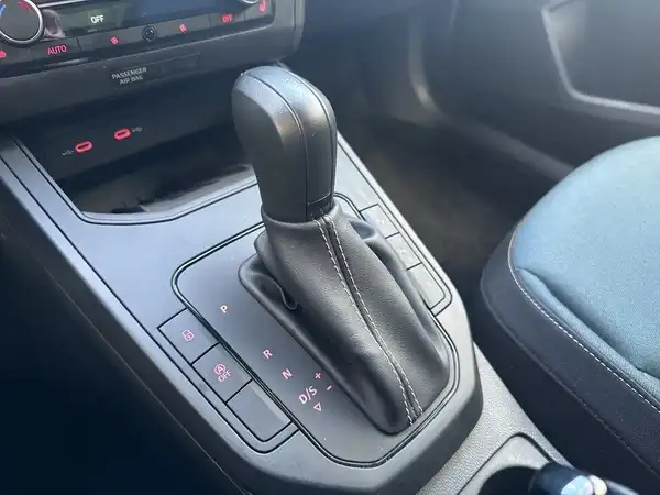 Innenaufnahme des Fahrzeugs, mit Schwerpunkt auf dem Schalthebel und den Bedienelementen.