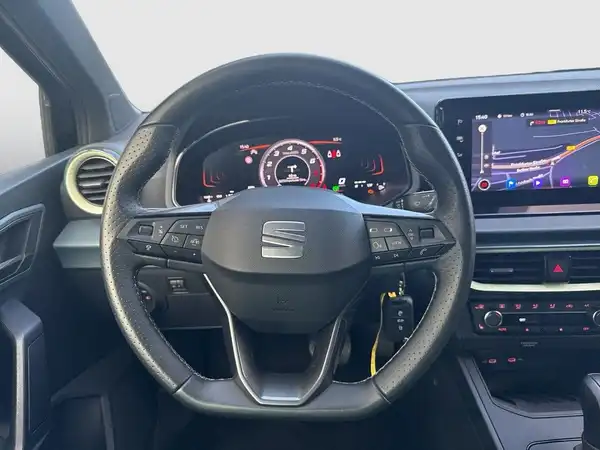 Das Bild zeigt das Innenraum eines SEAT Arona aus der Perspektive des Fahrers. Das Interieur ist schwarz.
