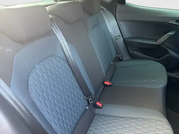 Das Bild zeigt die Rückbank des Fahrzeugs SEAT ARONA in dunklem Grau mit einem strukturierten Muster. Es handelt sich um eine Innenaufnahme.