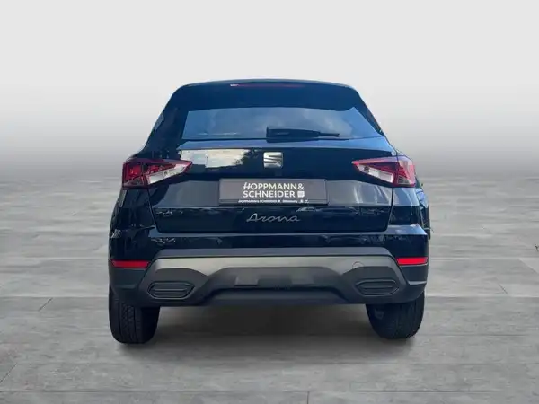 Das Bild zeigt einen schwarzen SEAT Arona von hinten. Es enthält das Händlerlogo 'Hoppmann & Schneider'.