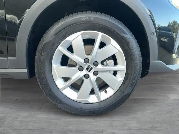 Das Bild zeigt die Seite eines SEAT Arona, wobei der Schwerpunkt auf dem Rad und der Felge liegt. Das Fahrzeug ist schwarz.