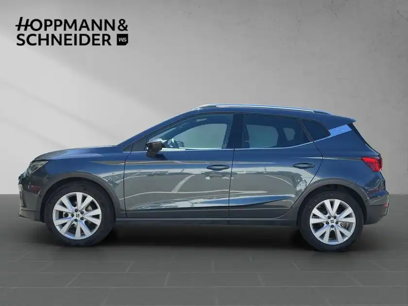 Seitliche Aufnahme eines blauen SEAT ARONA, mit Händlerlogo HOPPMANN & SCHNEIDER im Bild.