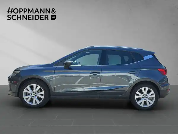 Seitliche Aufnahme eines blauen SEAT ARONA, mit Händlerlogo HOPPMANN & SCHNEIDER im Bild.