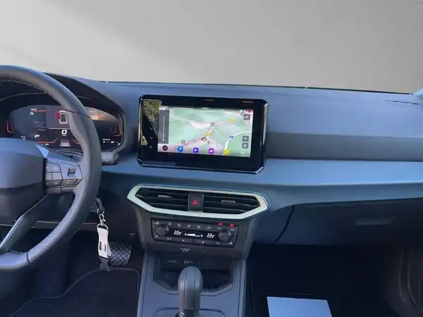 Das Bild zeigt den Innenraum eines Fahrzeugs. Es handelt sich um eine Aufnahme des Armaturenbretts mit einem Navigationsgerät.