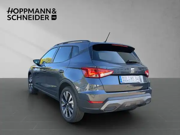 Das Bild zeigt einen SEAT ARONA von hinten in grauer Farbe. Es ist ein Fahrzeugfoto mit einem sichtbar eingetragenen Händlerlogo und markanten Texteinblendungen.