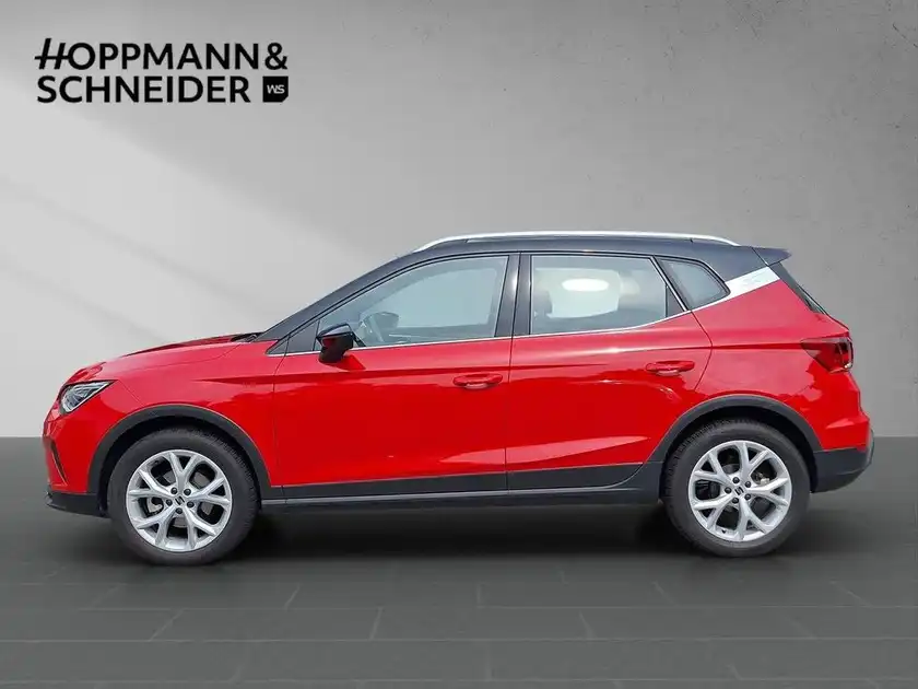Seitenansicht eines roten SEAT ARONA. Das Händlersymbol von HOPPMANN & SCHNEIDER ist eingeblendet.