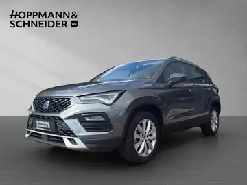 Das Bild zeigt einen grauen SEAT ATECA von der Seite, mit einem Händlerinformationslogo im oberen Bereich des Bildes.