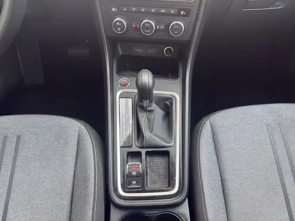 Das Bild zeigt den Innenraum eines Fahrzeugs, fokussiert auf die Mittelkonsole und die Sitze.