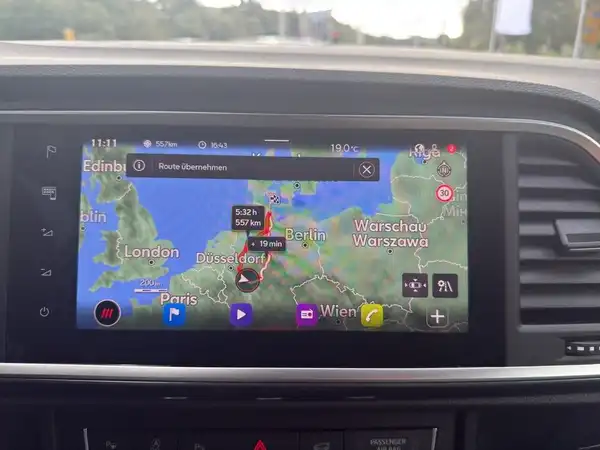 Das Bild zeigt eine Innenaufnahme des Fahrzeugs, speziell das Navigationsgerät. Es handelt sich um eine schwarze Innenausstattung.