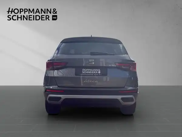 Das Bild zeigt einen schwarzen SEAT ATECA aus der Rückansicht, mit eingeblendetem Händlerlogo HOPPMANN & SCHNEIDER.