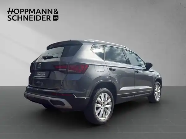 Das Bild zeigt einen grauen SEAT ATECA von hinten, mit dem Händlerlogo von Hoppmann & Schneider im oberen Bereich.
