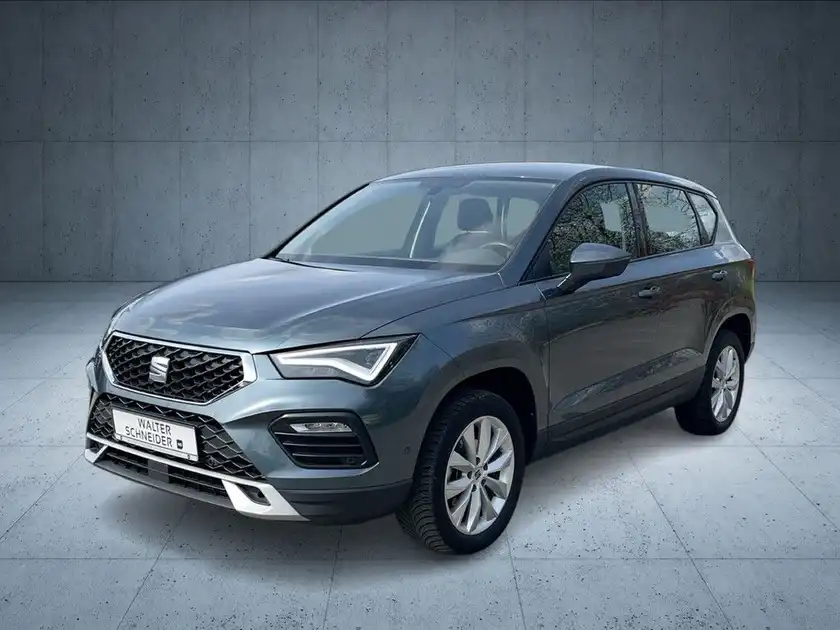 Das Bild zeigt einen SEAT Ateca von der Seite in grauer Farbe, mit Händlerlogo und markanten Texteinblendungen.
