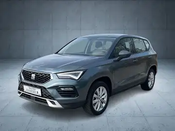 Das Bild zeigt einen SEAT Ateca von der Seite in grauer Farbe, mit Händlerlogo und markanten Texteinblendungen.