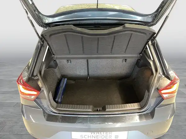 Das Bild zeigt den Kofferraum eines grauen SEAT IBIZA aus der Rückansicht. Auf dem Foto ist ein Händlerlogo sichtbar.