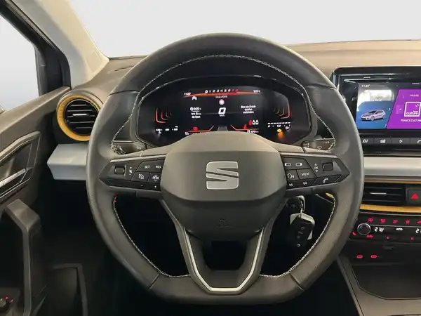 Das Bild zeigt das Innere eines SEAT IBIZA, aufgenommen aus der Perspektive des Fahrers. Das Interieur ist hauptsächlich schwarz.